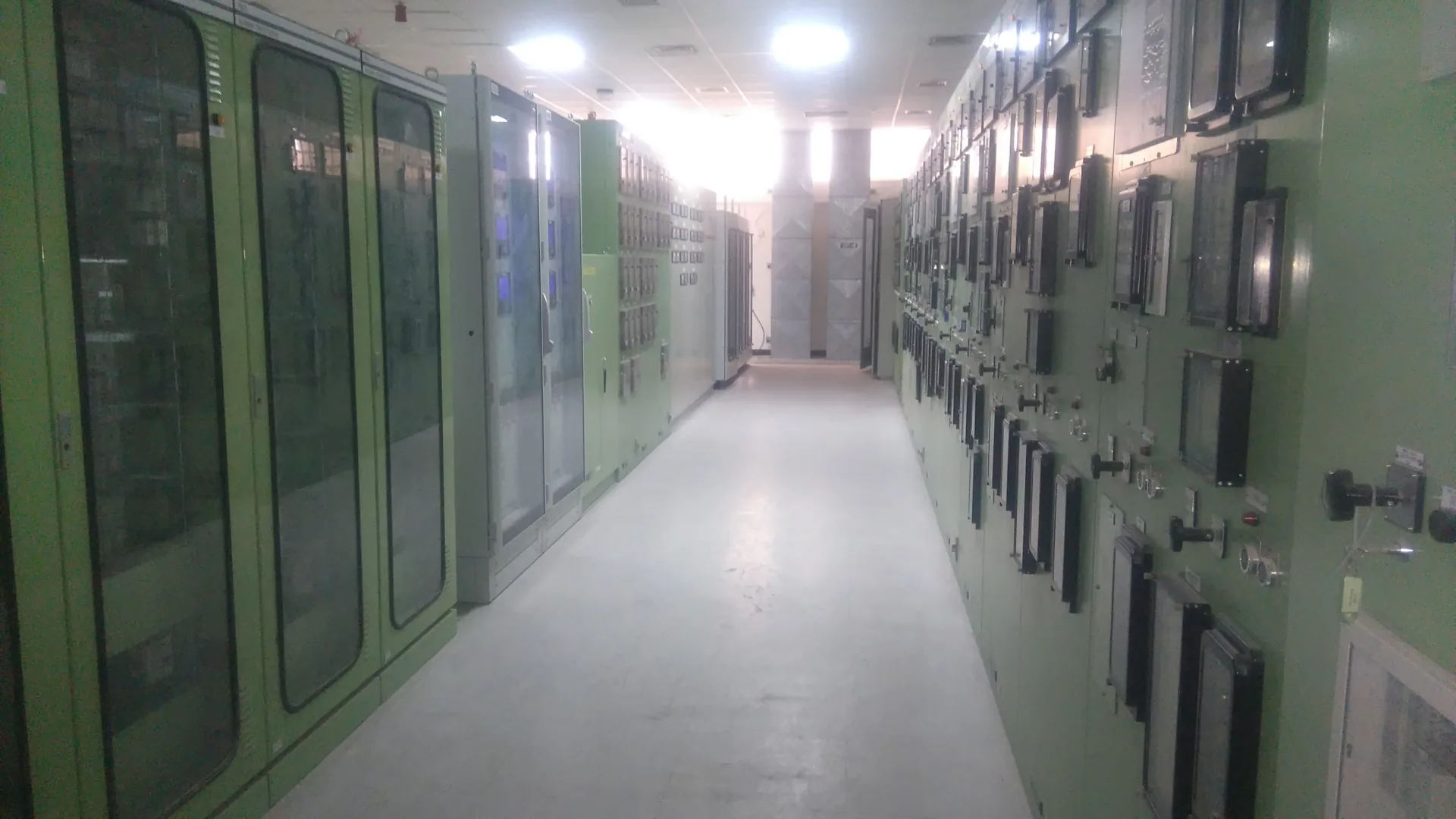 Switchgear and control cubicles down a substation corridor in Abu Dhabi